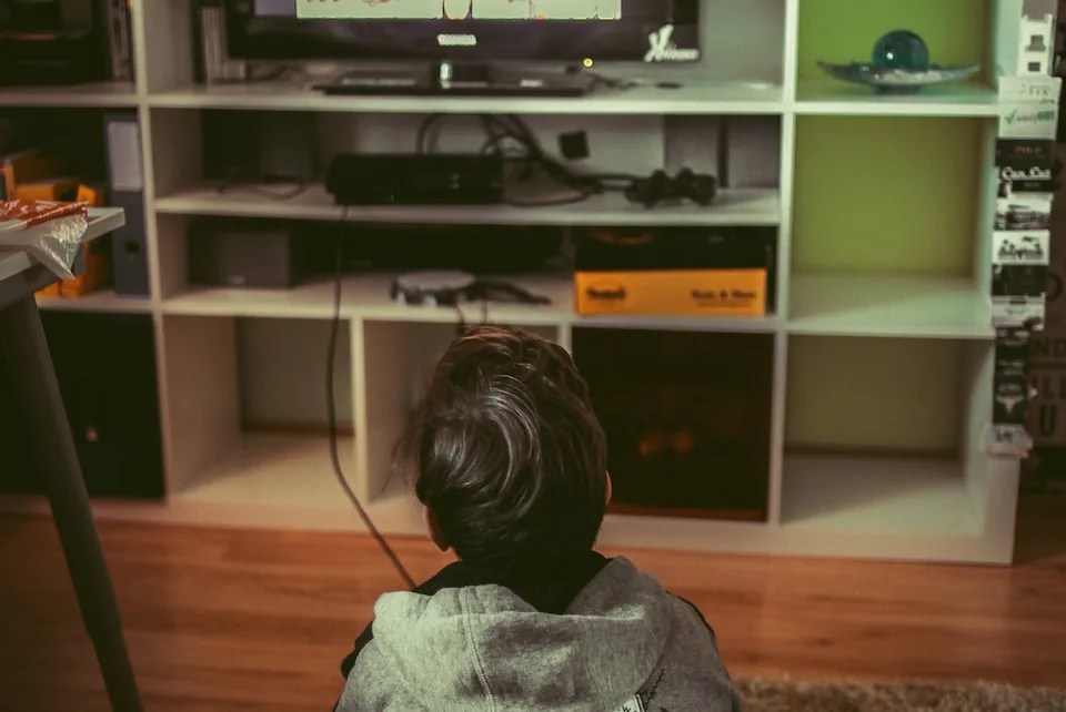 boy sitting on floor infront of TV